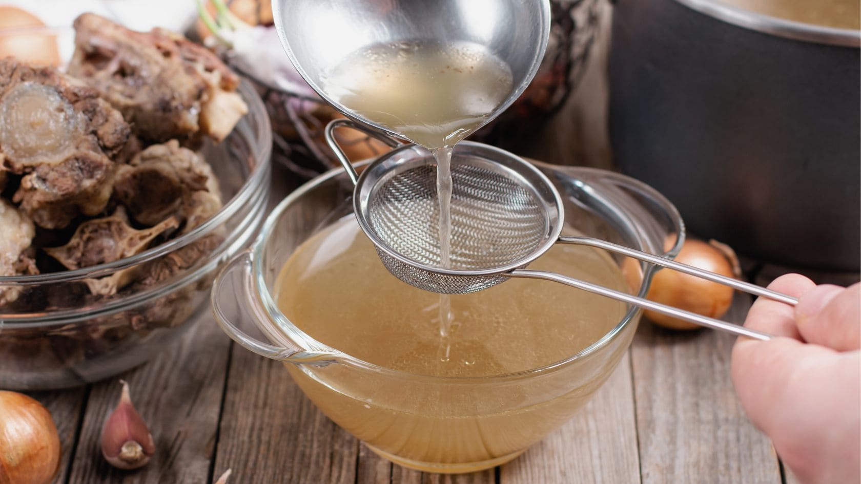 bone broth for allergies poured through a mesh sieve